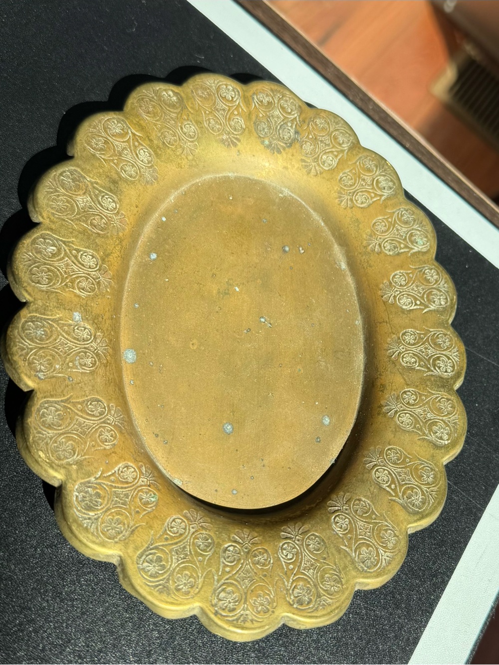Ornate scalloped edge brass plate with flower motifs